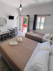 a bedroom with two beds and a table and a table at Anna Studios in Katapola