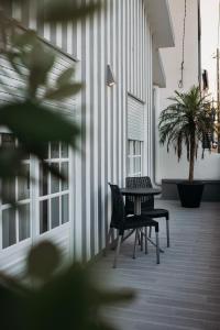 une terrasse avec 2 chaises, une table et une plante dans l'établissement Argus Dream Home, à Costa Nova
