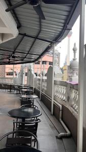 une rangée de tables et de chaises sur un balcon dans l'établissement Hotel AL Amin, à Kuala Lumpur