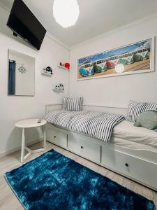 1 dormitorio con cama y alfombra azul en Argus Dream Home, en Costa Nova