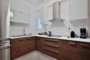 a kitchen with wooden cabinets and a stainless steel appliance at Melia Residence Acropolis - NEW in Athens