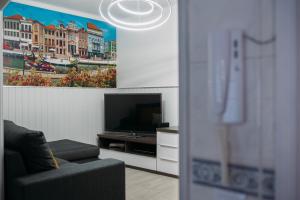 a living room with a tv and a couch and a painting at Argus Dream Home in Costa Nova