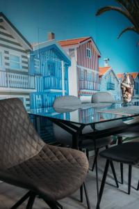 - une table et des chaises sur un balcon avec des maisons dans l'établissement Argus Dream Home, à Costa Nova