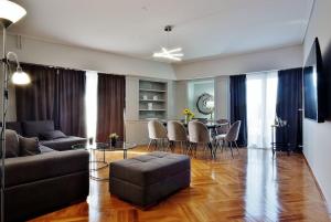 Melia Residence Acropolis - NEW في أثينا: غرفة معيشة مع أريكة وطاولة