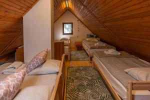 - un groupe de lits dans une chambre dotée de plafonds en bois dans l'établissement Chalet Bohinj, à Bohinj