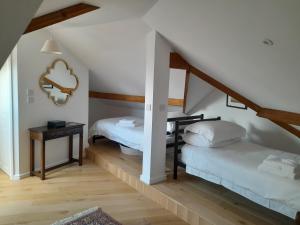 a attic room with two beds and a table at Dwynant - A Room with a View in Llangathen