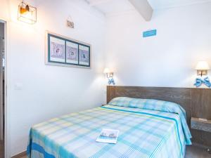 サントロペにあるHoliday Home Les Parcs de Gassin-4 by Interhomeのベッドルーム1室(ベッド1台、本付)