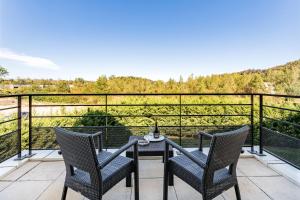 d'une terrasse avec 2 chaises et une table sur un balcon. dans l'établissement Best Western Hôtel des Barolles - Lyon Sud, à Brignais