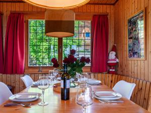 jadalnia z długim stołem i czerwonymi zasłonami w obiekcie Chalet Le Hibou by Interhome w mieście Nendaz