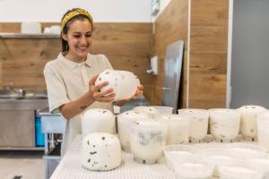 una mujer en una cocina sosteniendo una olla de queso en Camping Agrisalus, en Arco