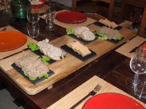 una mesa de madera cubierta con sándwiches y queso en Au Bois de la Grave, en Luzech