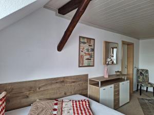 Schlafzimmer mit einem Bett und einem Kopfteil aus Holz in der Unterkunft Gaststätte und Pension Zur Schiene in Merseburg