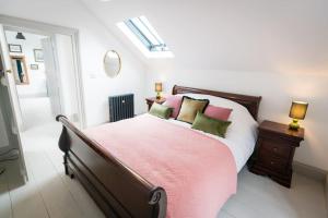 a bedroom with a bed with pink and green pillows at Hilltop Farm - Middle Barn luxury accommodation in Tansley