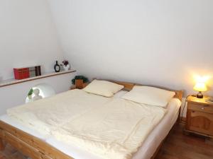 a bed in a room with a white wall at Apartment Odin-2 by Interhome in Galmsbüll