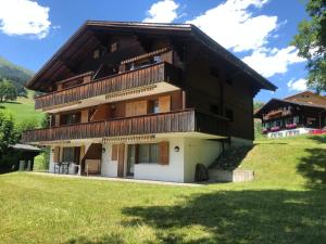 a large house with a gambrel roof at Apartment Chalet Sunneblick by Interhome in Grindelwald