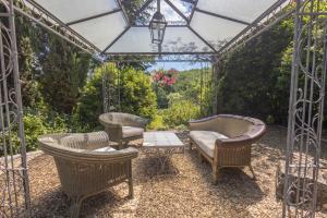 a pergola with wicker chairs and a table and a table at Il Casello Country House in Greve in Chianti