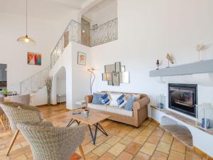 a living room with a couch and a fireplace at Villa Clos Romain by Interhome in Les Issambres