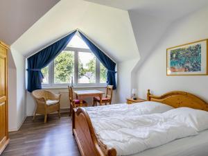 a bedroom with a bed and a table and a window at Holiday Home Losentitz-2 by Interhome in Zudar