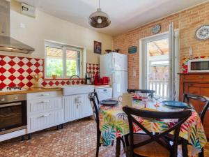 a kitchen with a table and chairs and a refrigerator at Holiday Home Poumeyrette by Interhome in Naujac-sur-Mer