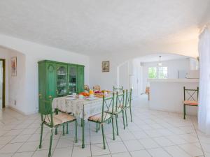 グリモーにあるHoliday Home Mas des Chênes - GRI120 by Interhomeのキッチン(テーブル、椅子、緑のキャビネット付)