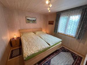 a small bedroom with a bed and a window at Chalet Margrith by Interhome in Oberwilen