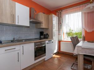 een keuken met witte kasten, een wastafel en een fornuis bij Apartment Am Strom-3 by Interhome in Ummanz
