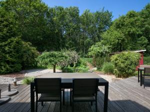 a black table and chairs on a wooden deck at Holiday Home Boddenruhe by Interhome in Ummanz