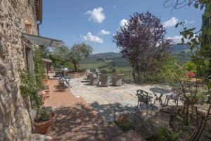 a patio with a bunch of chairs and tables at Il Casello Country House in Greve in Chianti