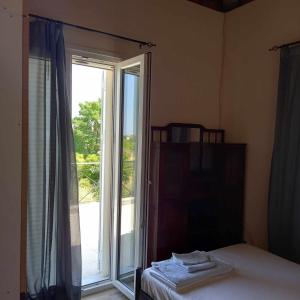 1 dormitorio con 1 cama y puerta corredera de cristal en Kalloni Village House, en Kalloni