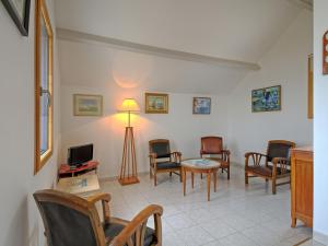a living room with chairs and a table and a tv at Holiday Home La Lousse by Interhome in Assérac