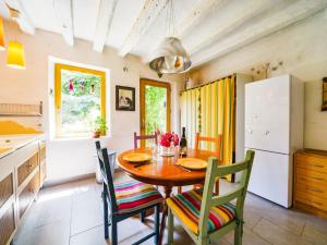 Il comprend une cuisine et une salle à manger avec une table et des chaises en bois. dans l'établissement Holiday Home Au Soleil Joyeux - CTU201 by Interhome, à Chissay-en-Touraine