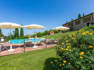 um jardim com piscina e guarda-sóis em Holiday Home Casa Mori by Interhome em Vico dʼElsa