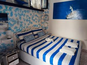 a bedroom with a bed with a blue and white striped blanket at Pino Marino in San Felice Circeo