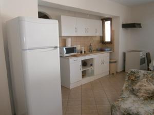 Il comprend une cuisine équipée d'un réfrigérateur blanc et d'un canapé. dans l'établissement Moraki Apartment, à Episkopión