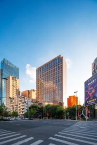 eine Stadtstraße mit einem Fußweg vor hohen Gebäuden in der Unterkunft Swissôtel Grand Shanghai in Shanghai