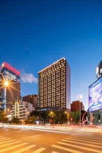 a city skyline with tall buildings at night at Swissôtel Grand Shanghai in Shanghai