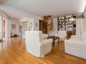 salon z białymi meblami i drewnianą podłogą w obiekcie Holiday Home Sammartano by Interhome w mieście Marsala