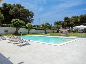 a swimming pool with chairs and a gazebo at Holiday Home Sammartano by Interhome in Marsala