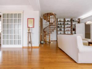 a living room with a white couch and a spiral staircase at Holiday Home Sammartano by Interhome in Marsala