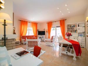 アルビールにあるHoliday Home Casa Sandra by Interhomeのリビングルーム(オレンジ色のカーテン、テーブル、椅子付)