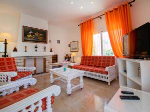 un soggiorno con mobili rossi e bianchi e TV di Holiday Home Casa Sandra by Interhome a Albir