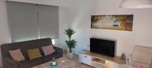 a living room with a couch and a flat screen tv at Vacaciones en Valencia in Burjassot