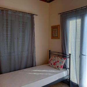 Cama en habitación con ventana y almohada en Kalloni Village House, en Kalloni