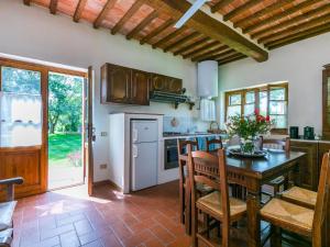 CinigianoにあるHoliday Home Mandorlo by Interhomeのキッチン(テーブル、椅子付)、ドア付きのキッチン