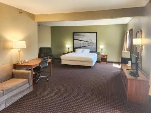 Le ClaireにあるEagle Ridge Innのベッド、デスク、テレビが備わるホテルルームです。