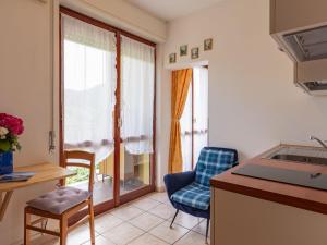 une cuisine avec une table et des chaises ainsi qu'une fenêtre dans l'établissement Apartment Euroville - LUI154 by Interhome, à Germignaga