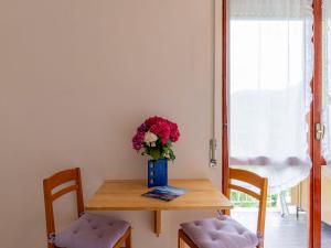 un tavolo con un vaso di fiori sopra di Apartment Euroville - LUI154 by Interhome a Germignaga Altre 24 foto