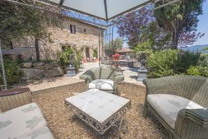 un patio con sedie e tavolo e un edificio di Il Casello Country House a Greve in Chianti