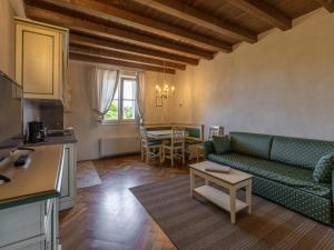 - un salon avec un canapé vert et une table dans l'établissement Apartment Winery Villa Vitas - App- 5 by Interhome, à Strassoldo