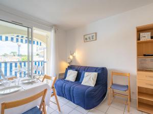 un salon avec un canapé bleu et une table dans l'établissement Apartment Parc de Pontaillac-21 by Interhome, à Pontaillac 16 autres photos